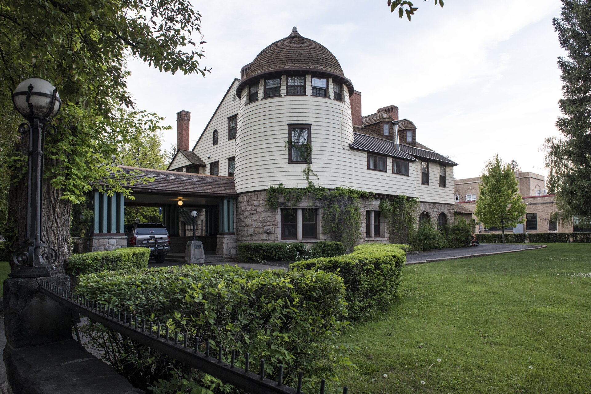 Historic 1888 Victorian mansion in Durango with a rounded shingled turret, ivy-covered stone walls and an old iron lamppost